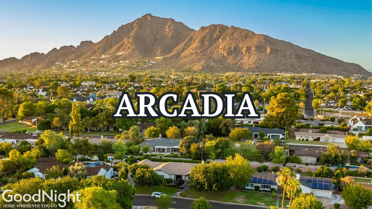 A panoramic view of a mountain range surrounded by lush greenery and residential homes nestled at the base. The scene radiates tranquility and adventure, highlighting the close proximity of hiking and biking opportunities like Camelback Mountain and the McDowell Sonoran Preserve.